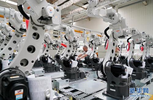 7月8日,唐山松下产业机器的工人在查看电焊机器人产品信. .
