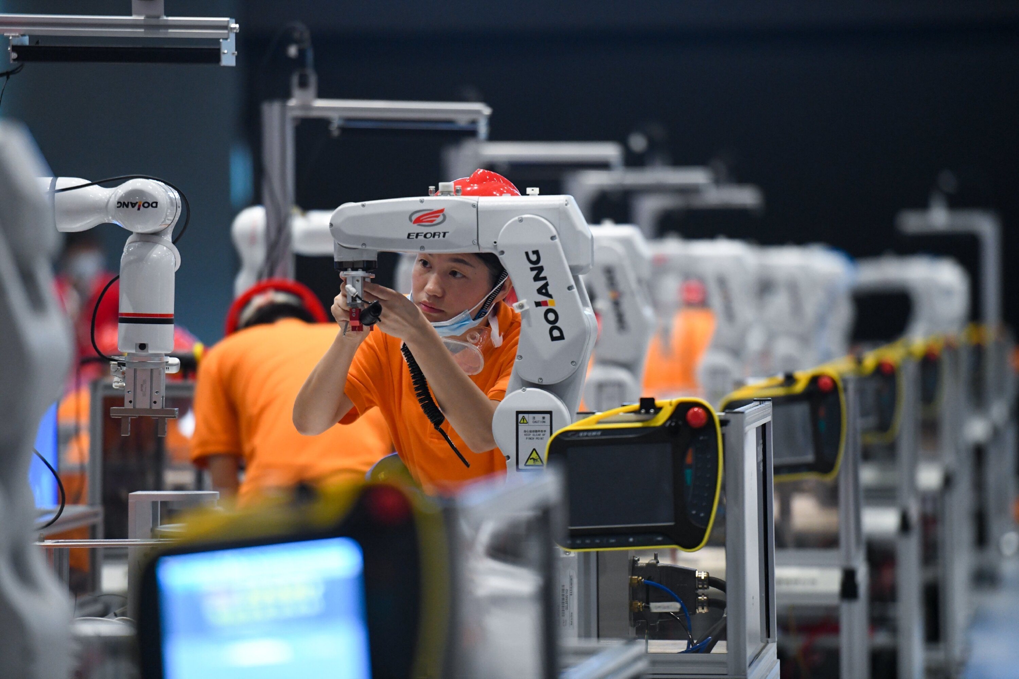 参赛选手在工业机器人技术应用项目比赛中进行操作& 新华社记者